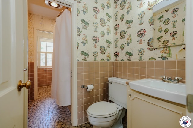 3519 Olive St, Texarkana, TX 75503 - bathroom with tile walls, wallpapered walls, vanity, toilet, and wainscoting