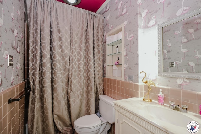 3519 Olive St, Texarkana, TX 75503 - full bathroom featuring wallpapered walls, tile walls, vanity, toilet, and a wainscoted wall