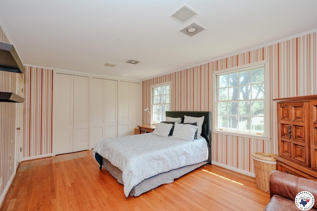 3519 Olive St, Texarkana, TX 75503 - bedroom with wallpapered walls, light wood-style floors, baseboards, and multiple closets