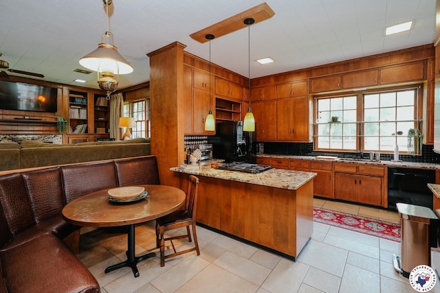 3519 Olive St, Texarkana, TX 75503 - kitchen with black appliances, a peninsula, decorative backsplash, brown cabinets, and decorative light fixtures
