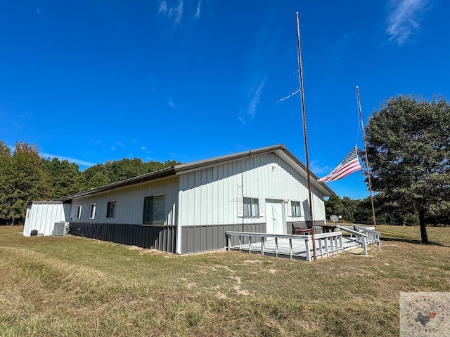 view of side of home featuring central air condition unit and a lawn