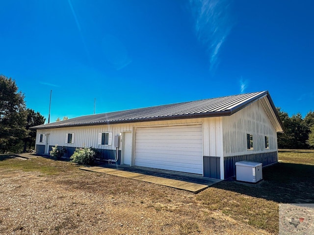 view of side of home featuring a garage and a lawn