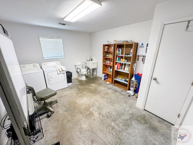 washroom featuring a textured ceiling and washer and clothes dryer