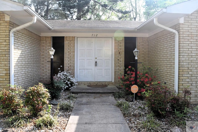 712 Diane Dr, Wake Village, TX 75501 - doorway to property featuring brick siding and a shingled roof