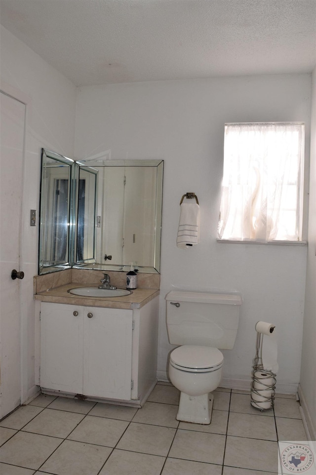 bathroom featuring a textured ceiling, toilet, vanity, and tile patterned flooring