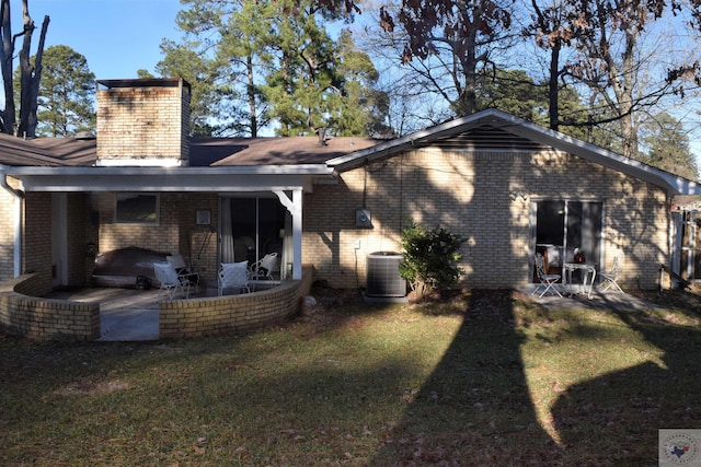 back of house featuring central AC unit, a patio area, and a yard