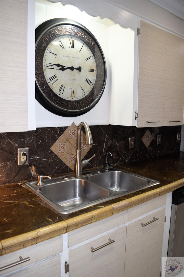 room details featuring sink, dishwashing machine, and tasteful backsplash