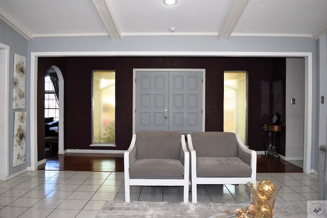 entryway with beam ceiling, tile patterned flooring, and ornamental molding