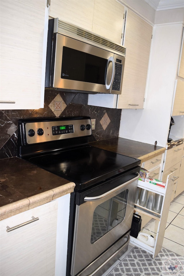 kitchen featuring light tile patterned floors, appliances with stainless steel finishes, and tasteful backsplash