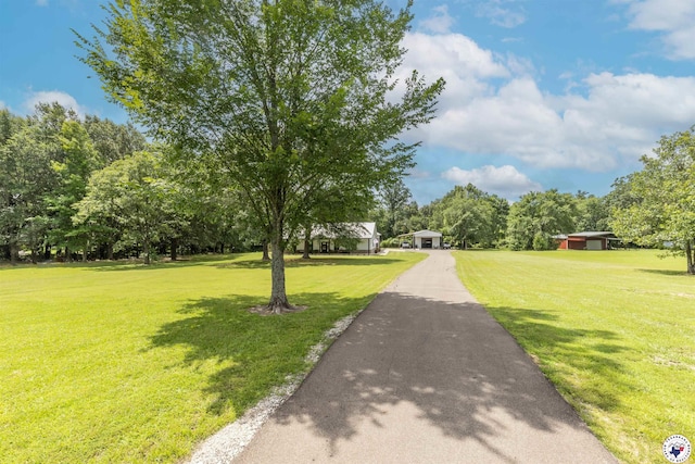 113 Dove Crk, New Boston, TX 75570 - view of property's community featuring a yard, a detached garage, asphalt driveway, and view of scattered trees