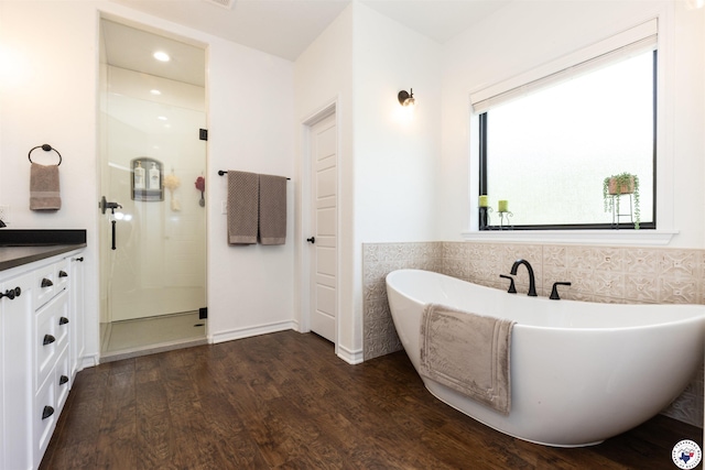 113 Dove Crk, New Boston, TX 75570 - full bathroom featuring a shower stall, wood finished floors, a freestanding tub, vanity, and tile walls
