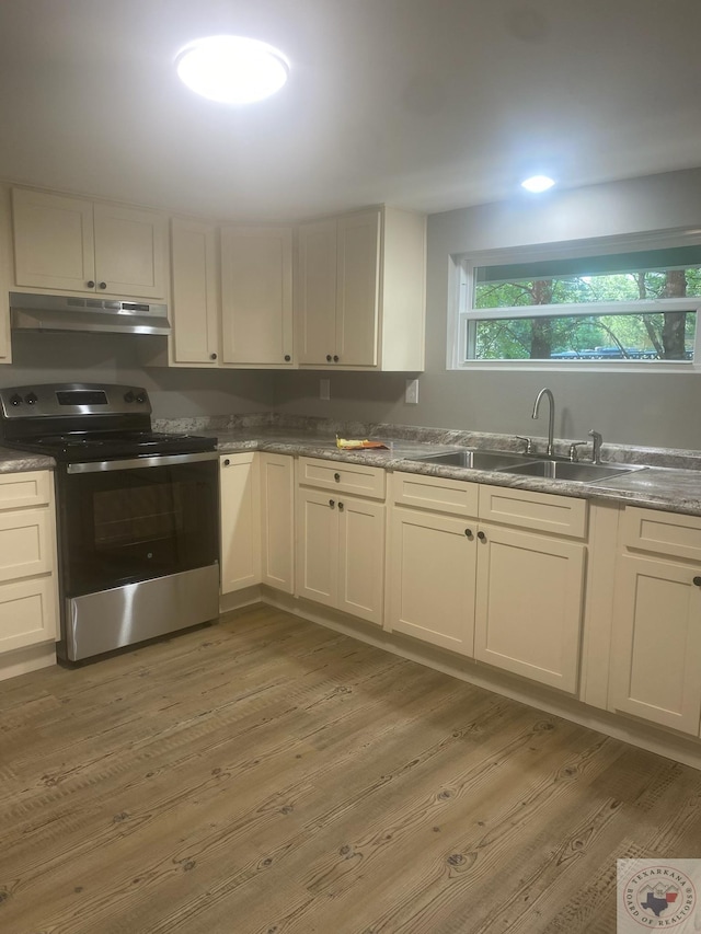 kitchen with sink, light wood-type flooring, white cabinetry, and stainless steel electric stove