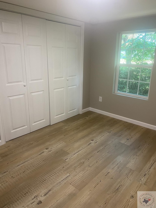 unfurnished bedroom with a closet and light hardwood / wood-style flooring