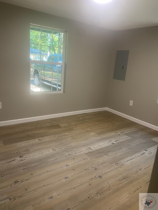 unfurnished room with hardwood / wood-style flooring and electric panel