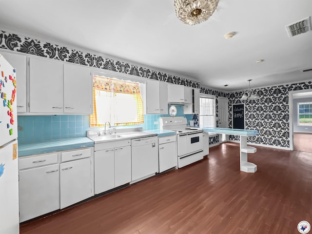 3223 Walnut St, Texarkana, TX 75503 - kitchen featuring white appliances, wallpapered walls, dark wood-style flooring, white cabinets, and plenty of natural light