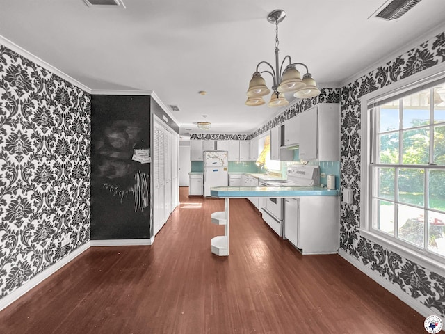 3223 Walnut St, Texarkana, TX 75503 - dining area with wallpapered walls, dark wood-style floors, a chandelier, and crown molding