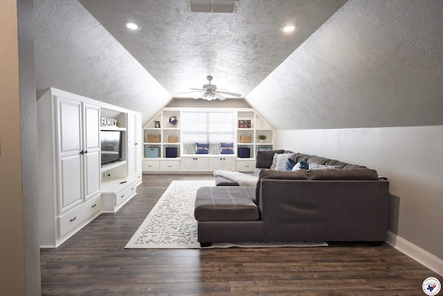 living room with a textured ceiling, visible vents, built in shelves, lofted ceiling, and dark wood-type flooring