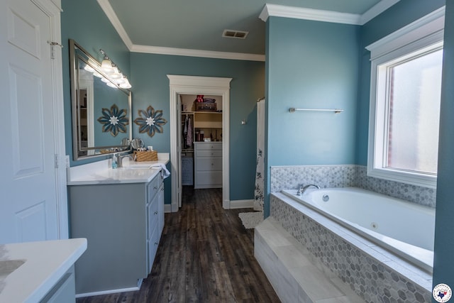bathroom with visible vents, crown molding, a garden tub, vanity, and wood finished floors