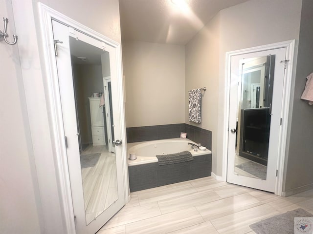 bathroom featuring a relaxing tiled tub