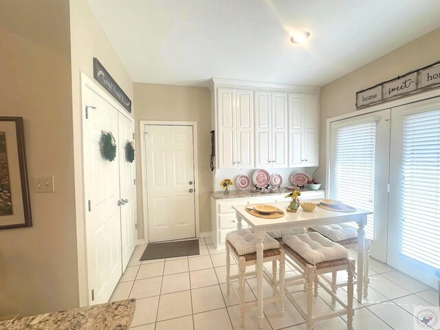 kitchen featuring white cabinets and light tile patterned flooring