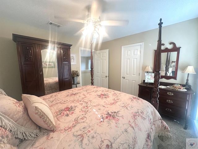 bedroom with a textured ceiling, carpet flooring, and ceiling fan