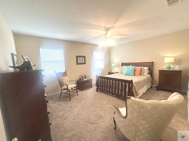 bedroom with a textured ceiling, carpet flooring, and ceiling fan