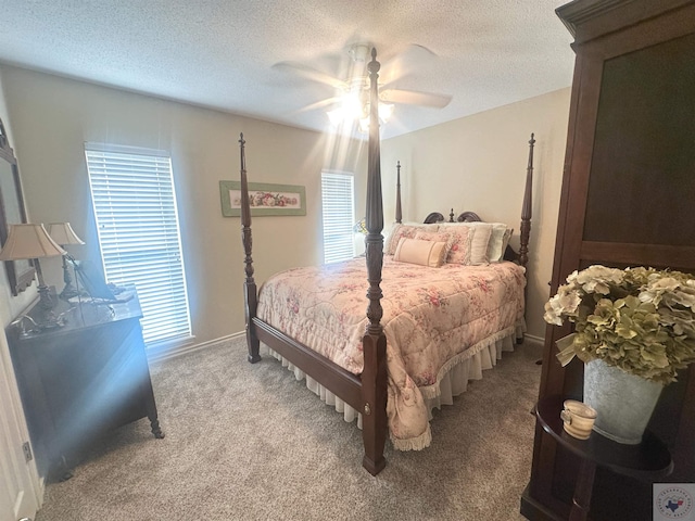 carpeted bedroom featuring ceiling fan and a textured ceiling