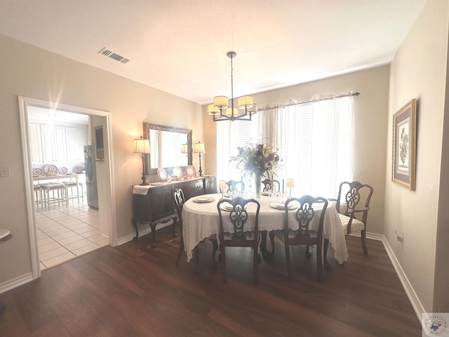 dining room featuring dark wood-type flooring and a chandelier