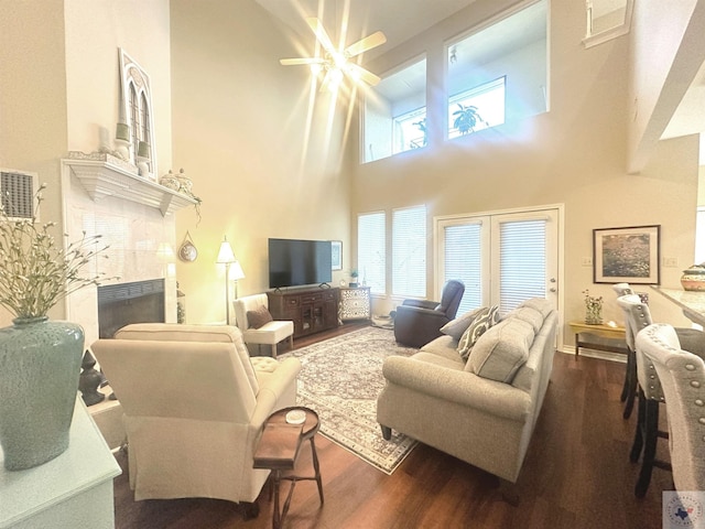 living room with dark hardwood / wood-style floors, a high ceiling, and a high end fireplace