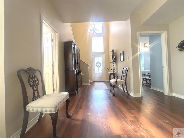 living area featuring a towering ceiling and dark wood-type flooring