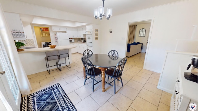 9 Camelia Ln, Texarkana, TX 75503 - dining space with washer / clothes dryer, a chandelier, crown molding, light tile patterned floors, and baseboards