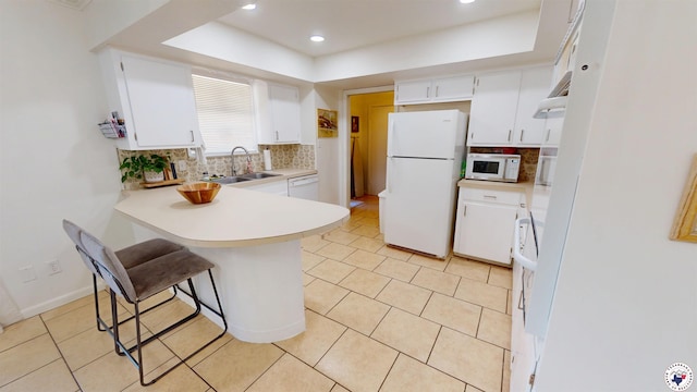 9 Camelia Ln, Texarkana, TX 75503 - kitchen with white appliances, a peninsula, tasteful backsplash, a sink, and recessed lighting