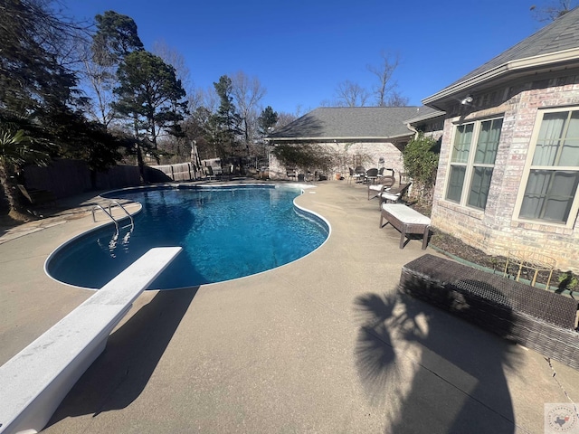 view of swimming pool with a fenced in pool, a patio area, fence, and a diving board