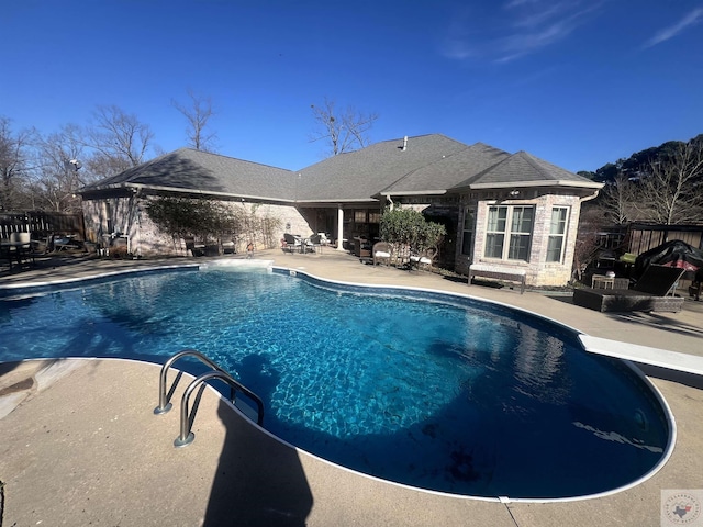 view of pool featuring a fenced in pool, a patio area, fence, and a diving board