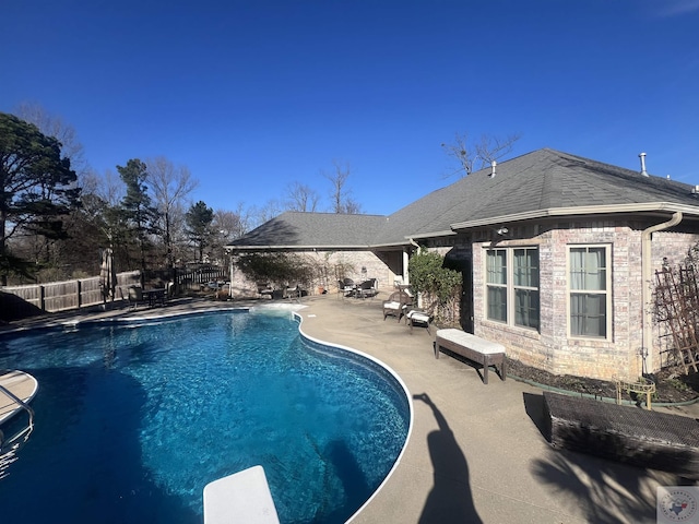 view of pool featuring fence, a diving board, a fenced in pool, and a patio