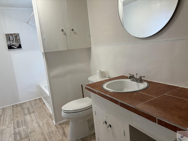 bathroom featuring hardwood / wood-style flooring, toilet, and vanity