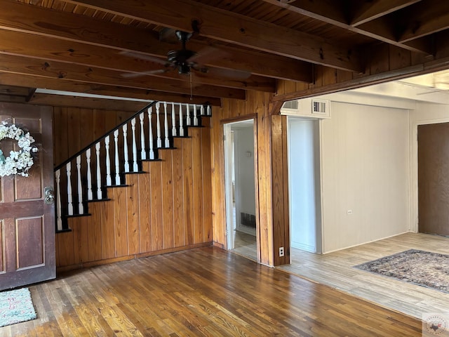 interior space with wood ceiling, wood-type flooring, wooden walls, ceiling fan, and beam ceiling