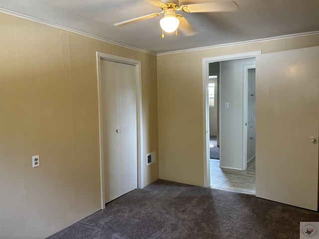 carpeted spare room with ceiling fan and ornamental molding