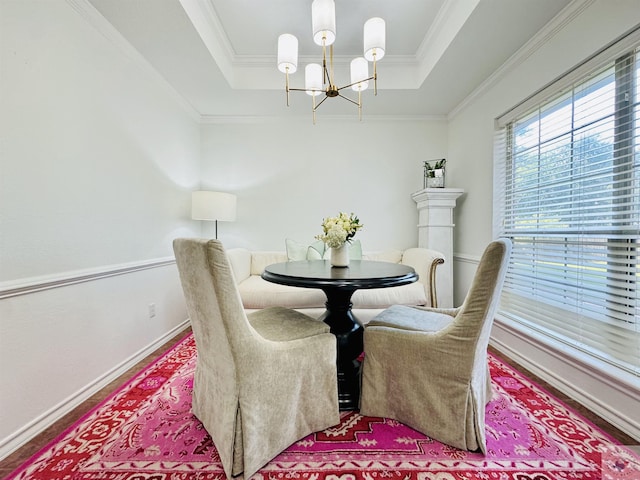 dining space with ornamental molding, an inviting chandelier, and a tray ceiling