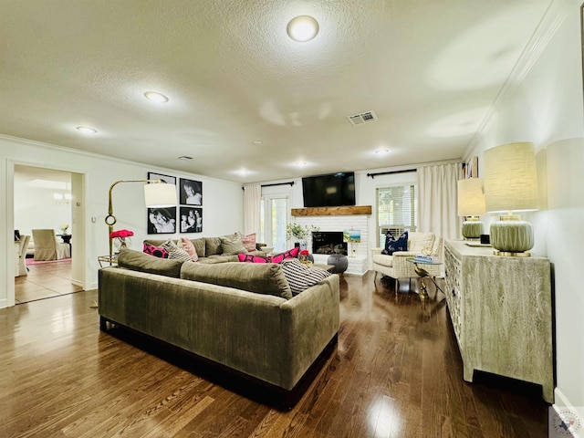 living room with ornamental molding, dark hardwood / wood-style flooring, and a textured ceiling