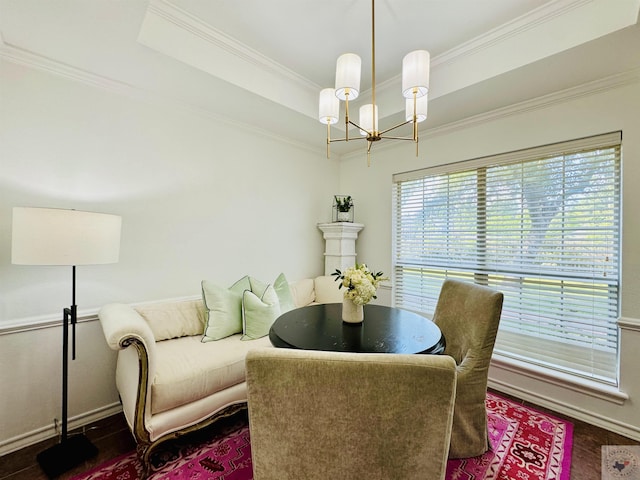 dining room with dark hardwood / wood-style floors, a tray ceiling, a notable chandelier, and ornamental molding