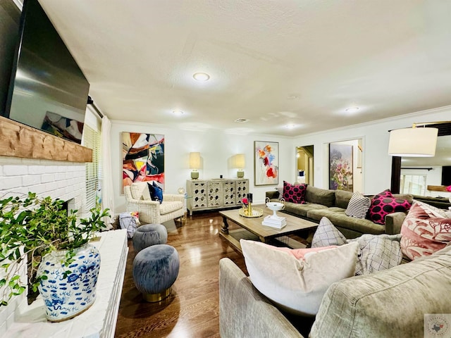 living room with hardwood / wood-style flooring, a textured ceiling, and a fireplace