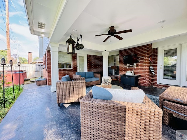 view of patio / terrace featuring ceiling fan, a hot tub, and an outdoor living space