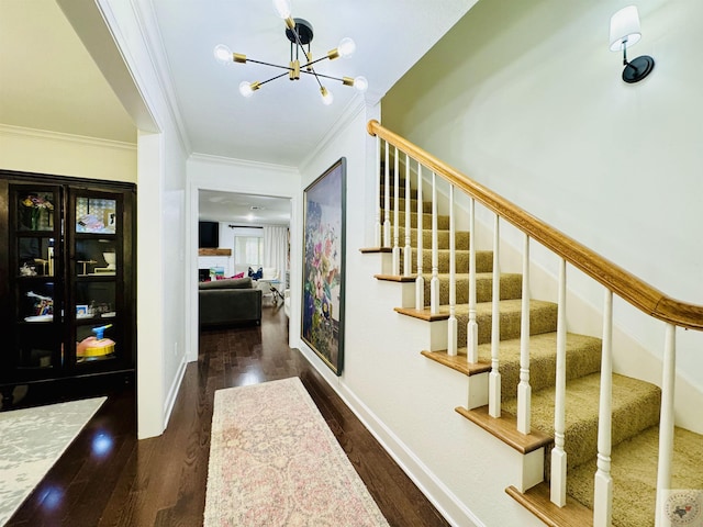 stairs with a chandelier, crown molding, and wood-type flooring