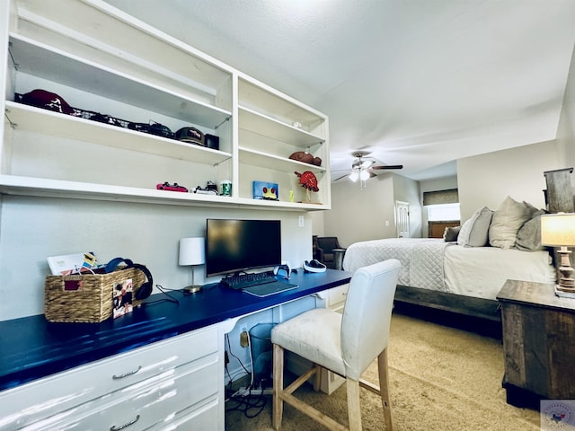 carpeted bedroom with ceiling fan and built in desk