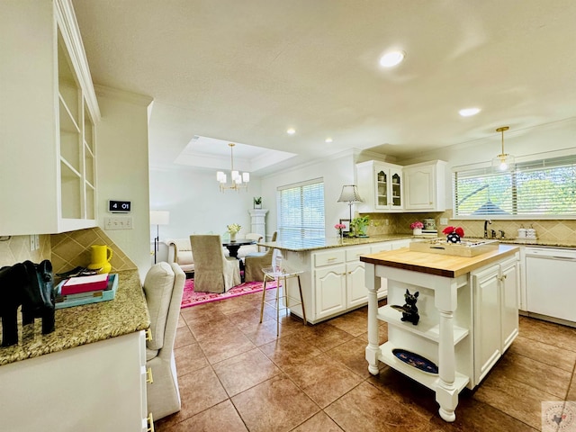 kitchen featuring white cabinets, dishwasher, a center island, and decorative light fixtures