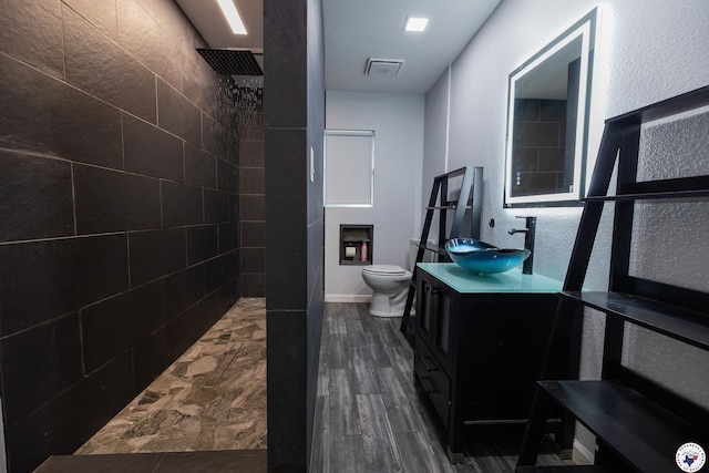 full bathroom with visible vents, walk in shower, toilet, vanity, and wood finished floors