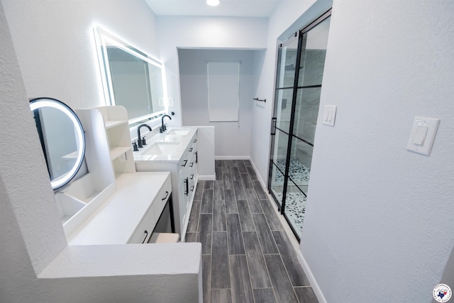 bathroom featuring a shower stall, vanity, baseboards, and wood finish floors