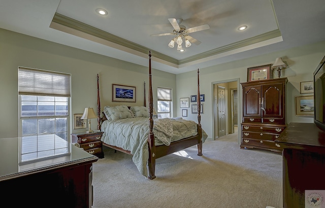 bedroom featuring ceiling fan, light carpet, and a tray ceiling