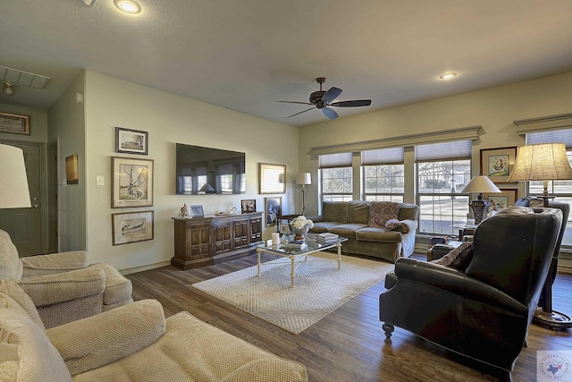 living room with ceiling fan and dark wood-type flooring